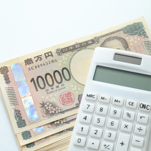 一万円札の束と電卓